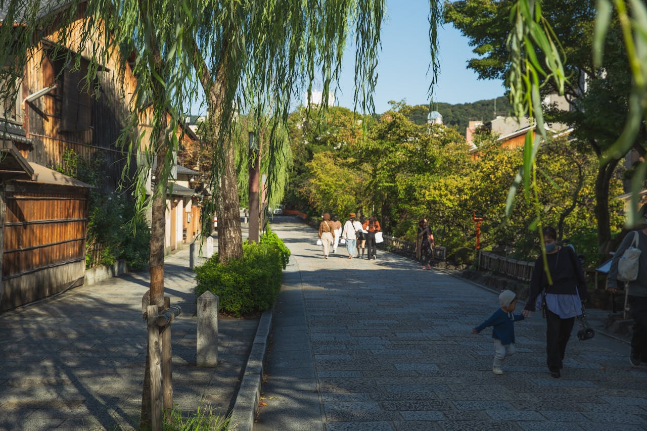 Explore the picturesque streets of Kyoto, Japan, with lush greenery and traditional wooden architecture.
